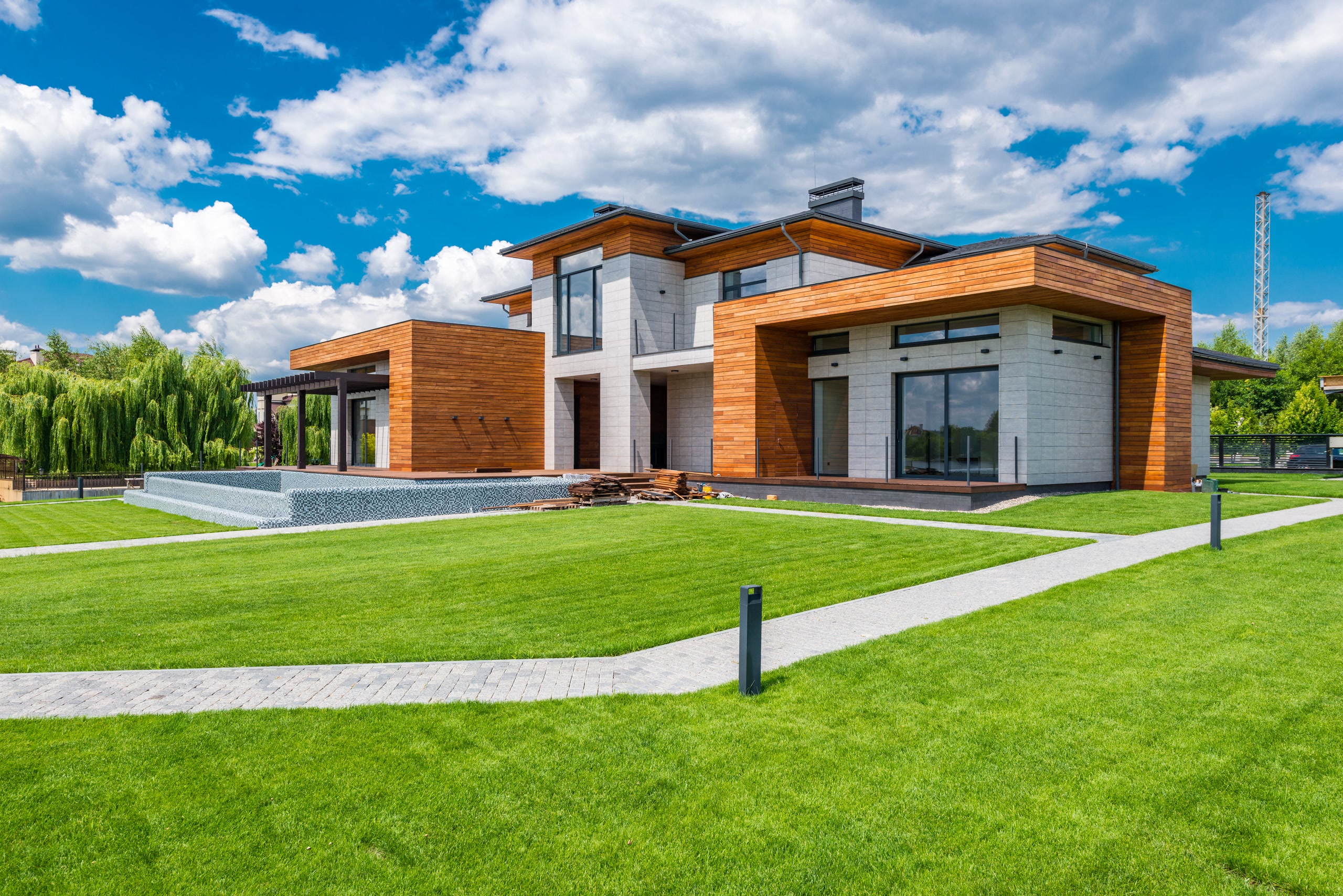 Modern home with wood cladding, lawn and pool terrace